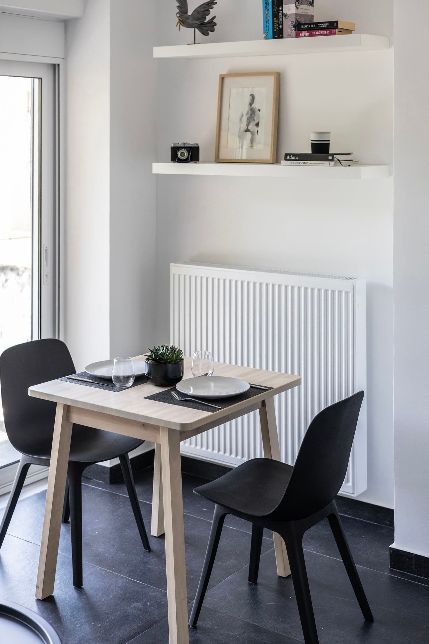 Minimalist dining corner with a wooden table and black chairs